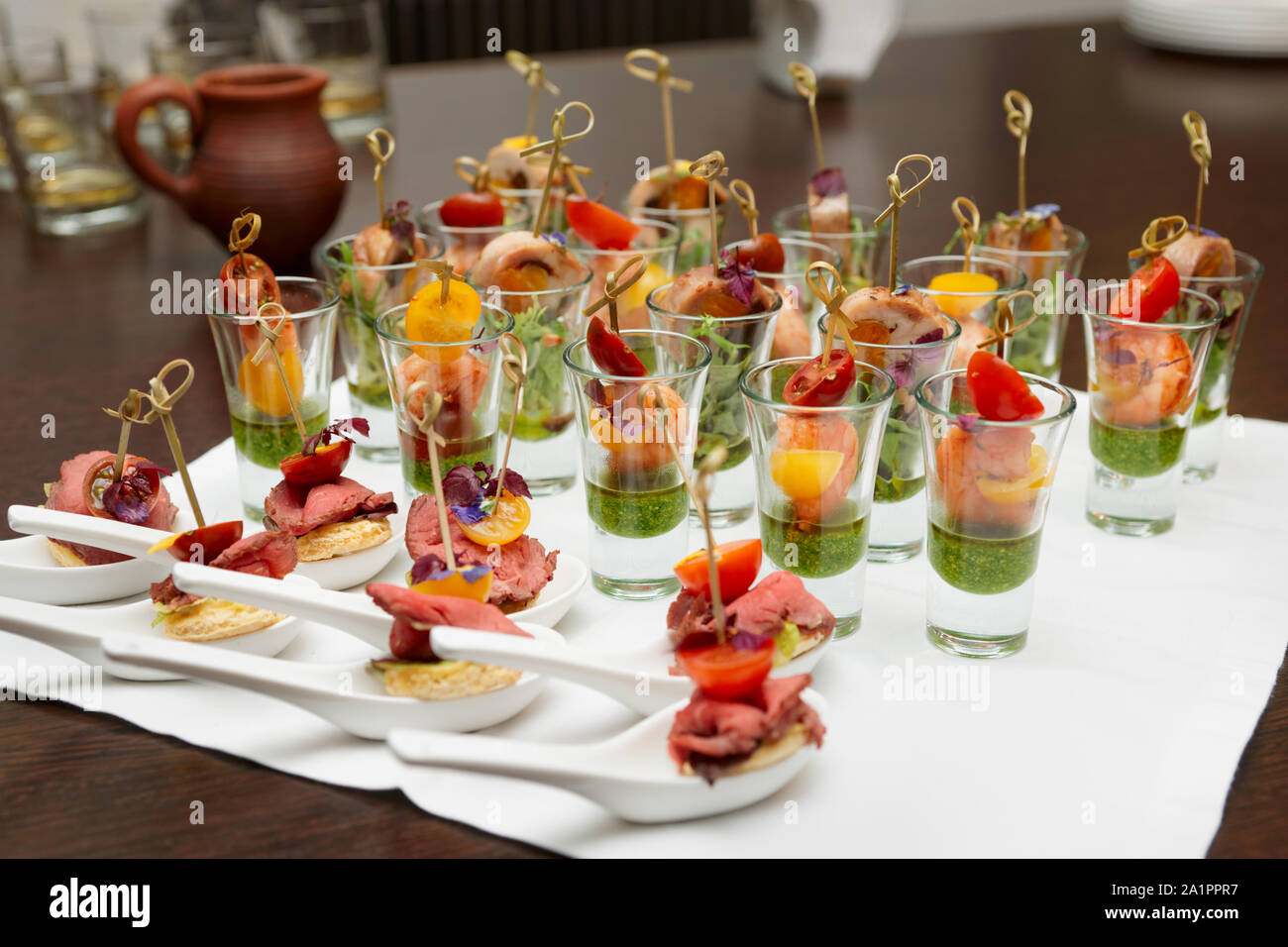 Varios bocados de carne y marisco en shot gafas en la mesa Fotografía de  stock - Alamy