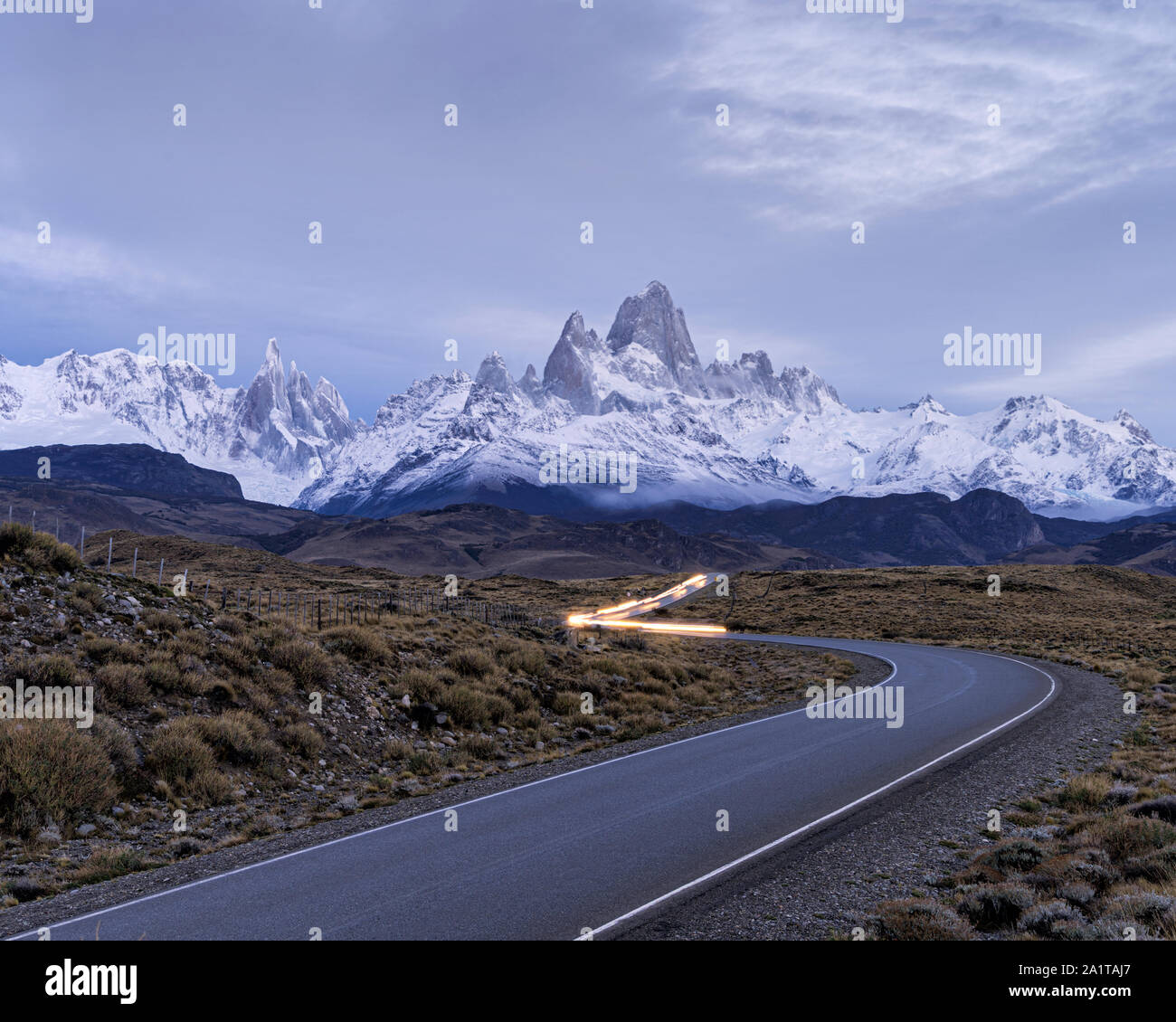La carretera a El Chalten con coche de estelas de luz en la carretera y el monte Fitzroy y el cerro Torre en el fondo Foto de stock