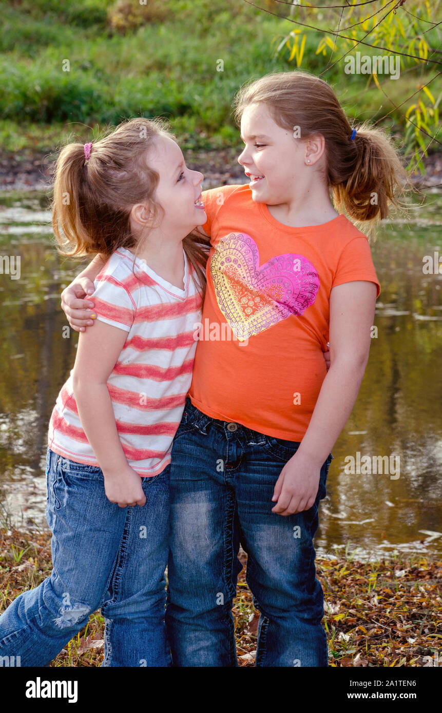 Dos niñas son hermanas y mejores amigas, ya que posan para una foto al aire  libre Fotografía de stock - Alamy