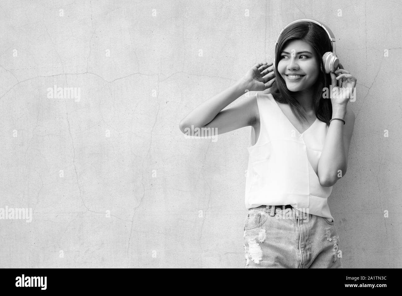 Hermosa joven escuchando música con auriculares al aire libre Foto de stock