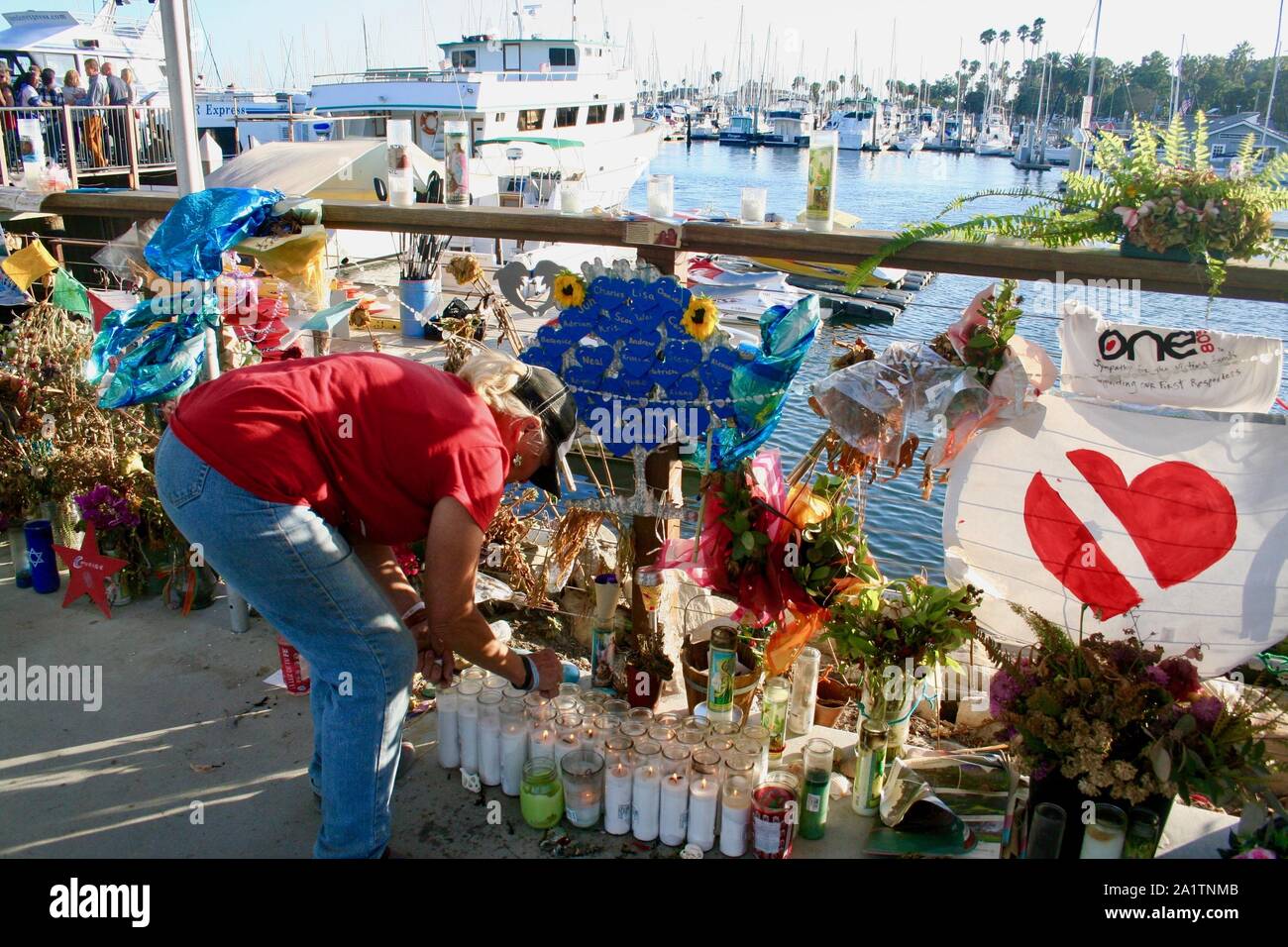 En Santa Bárbara, California, Estados Unidos. 28 Sep, 2019. Memorial por las víctimas de botes de buceo perdido en el mar sigue firme en el mar barco de desembarco dock, en el Puerto de Santa Bárbara, donde la concepción se albergaban antes del Día del Trabajo accidente que mató a 34 personas en tres días de vacaciones a las Islas del Canal de la Mancha. Una compañía de cruceros recientemente puso en marcha un cerco y toldo, y los turistas son curiosos y reverente mientras caminan por el memorial. Fotos de quienes perdieron sus vidas están rodeados de flores, muchos ahora secos, pero con frescas oneÃs sigue llevando a diario. Cada noche hay velas encendidas b Foto de stock