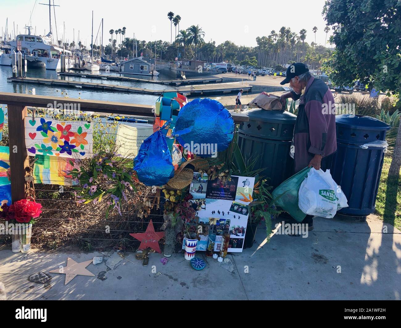 En Santa Bárbara, California, Estados Unidos. 28 Sep, 2019. Un hombre recoge a través de la papelera en el borde del Memorial de las víctimas de botes de buceo perdido en el mar sigue firme y transformar en el mar barco de desembarco dock, en el Puerto de Santa Bárbara, donde la concepción se albergaban antes del Día del Trabajo accidente que mató a 34 personas en tres días de vacaciones a las Islas del Canal de la Mancha. Las familias y amigos de los fallecidos han visitado el sitio ritual durante tres semanas, procedentes de países tan lejanos como Singapur y la India con sus seres oneÃs cenizas y fotos. Una compañía de cruceros recientemente puso en marcha un cerco y toldo, y Foto de stock