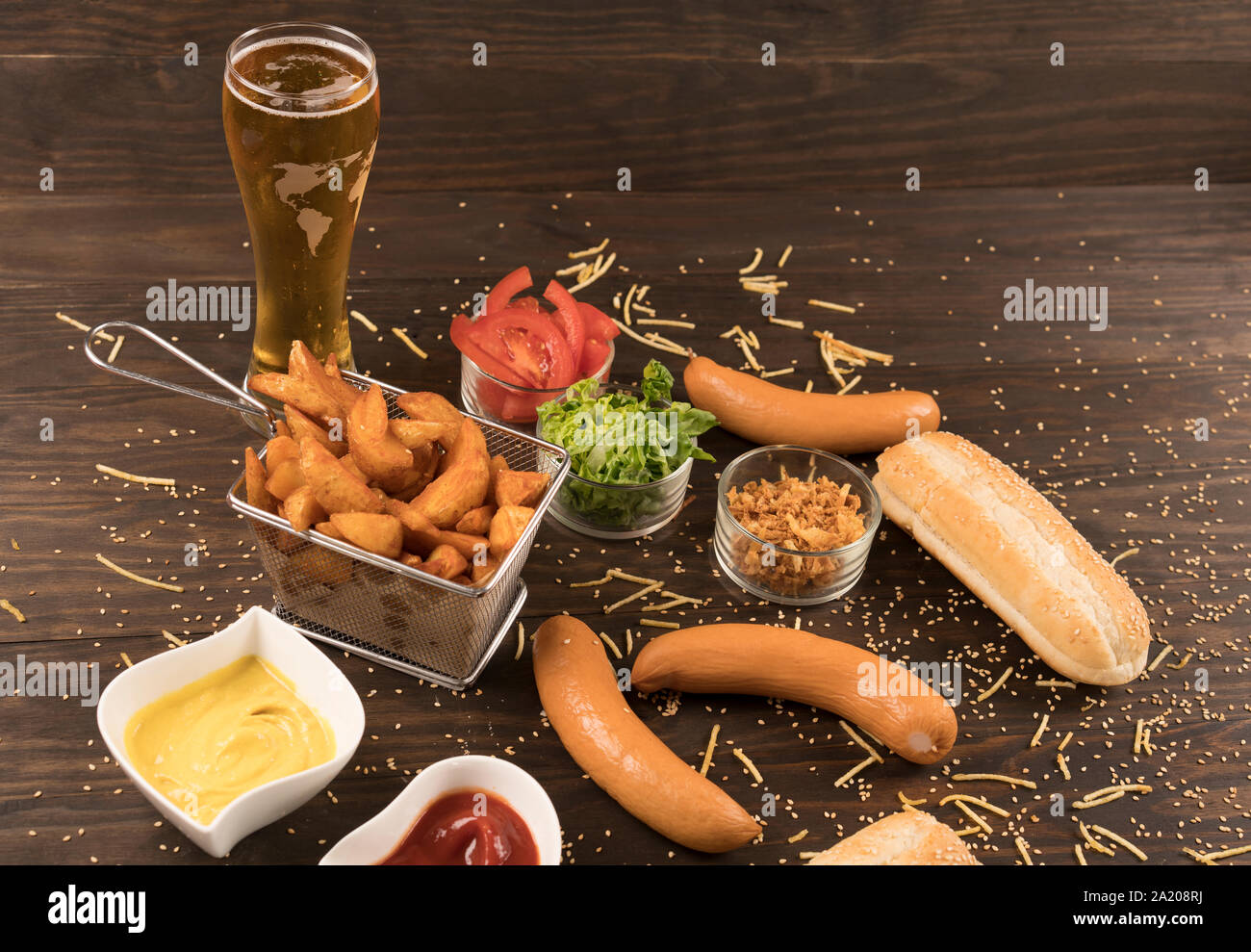 Salchichas con diversos condimentos en madera bord con cerveza fría Foto de stock