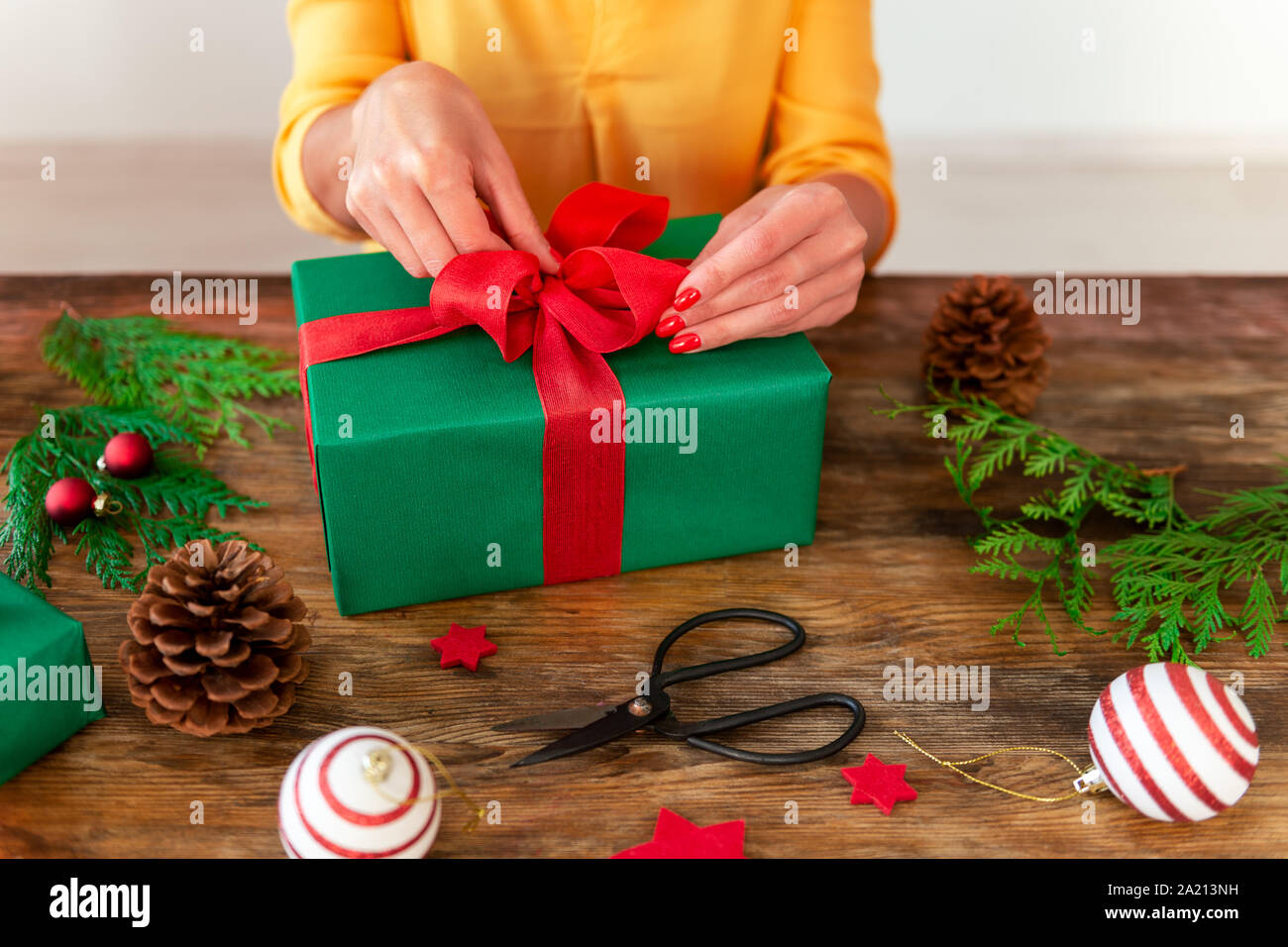 Bricolaje de envoltura de regalos. Mujer hermosa envoltura de regalo de  Navidad sobre mesa de madera rústica. Captura recortada de navidad la  estación de encintado Fotografía de stock - Alamy