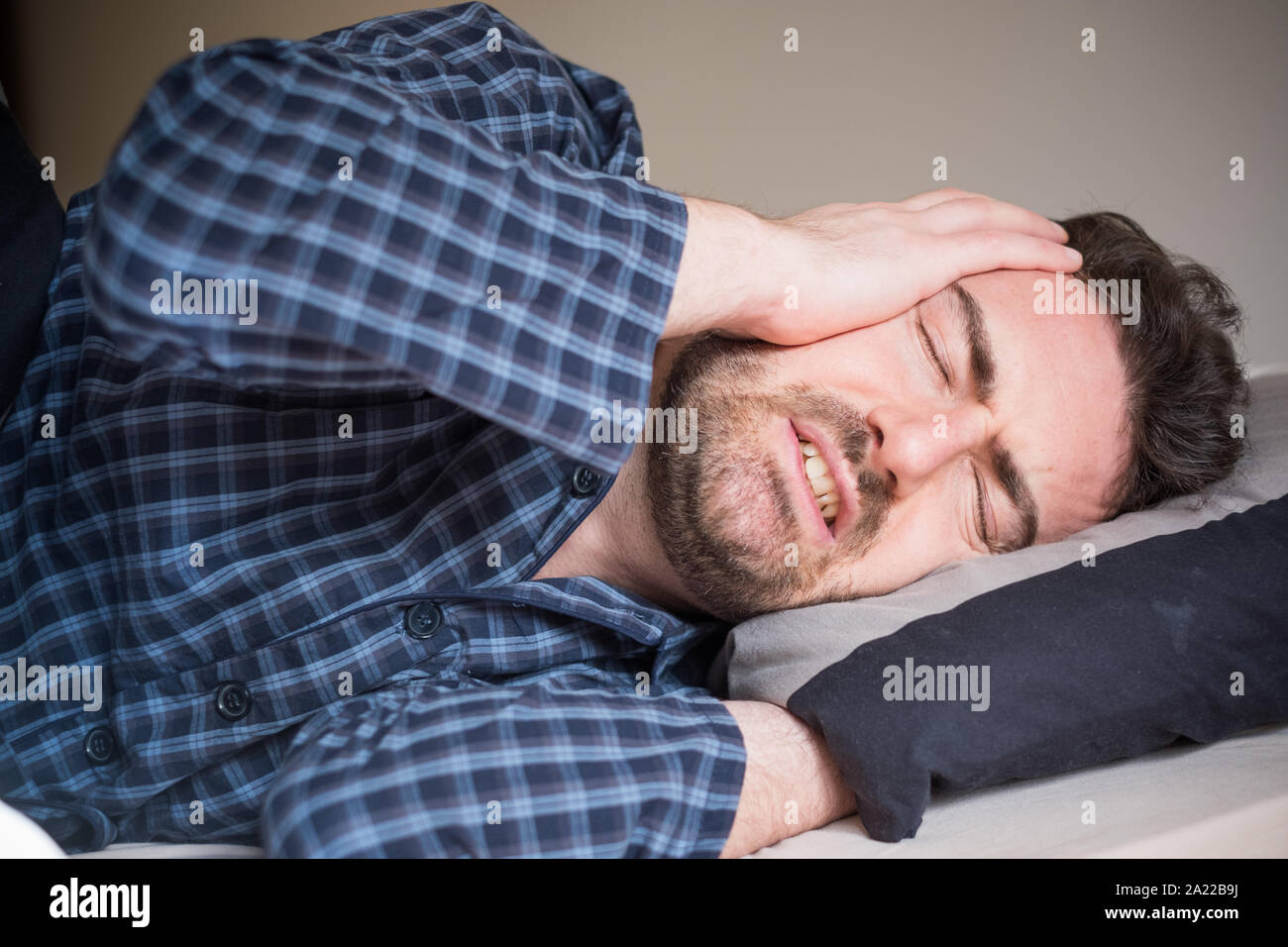 Hombre teniendo problema para dormir en su cama Foto de stock