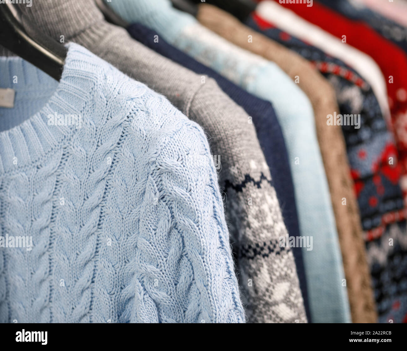Más allá Rubicundo Fanático Varios suéteres tejidos y jerséis en Hanger rack en una tienda de ropa o en  un armario, el enfoque selectivo Fotografía de stock - Alamy