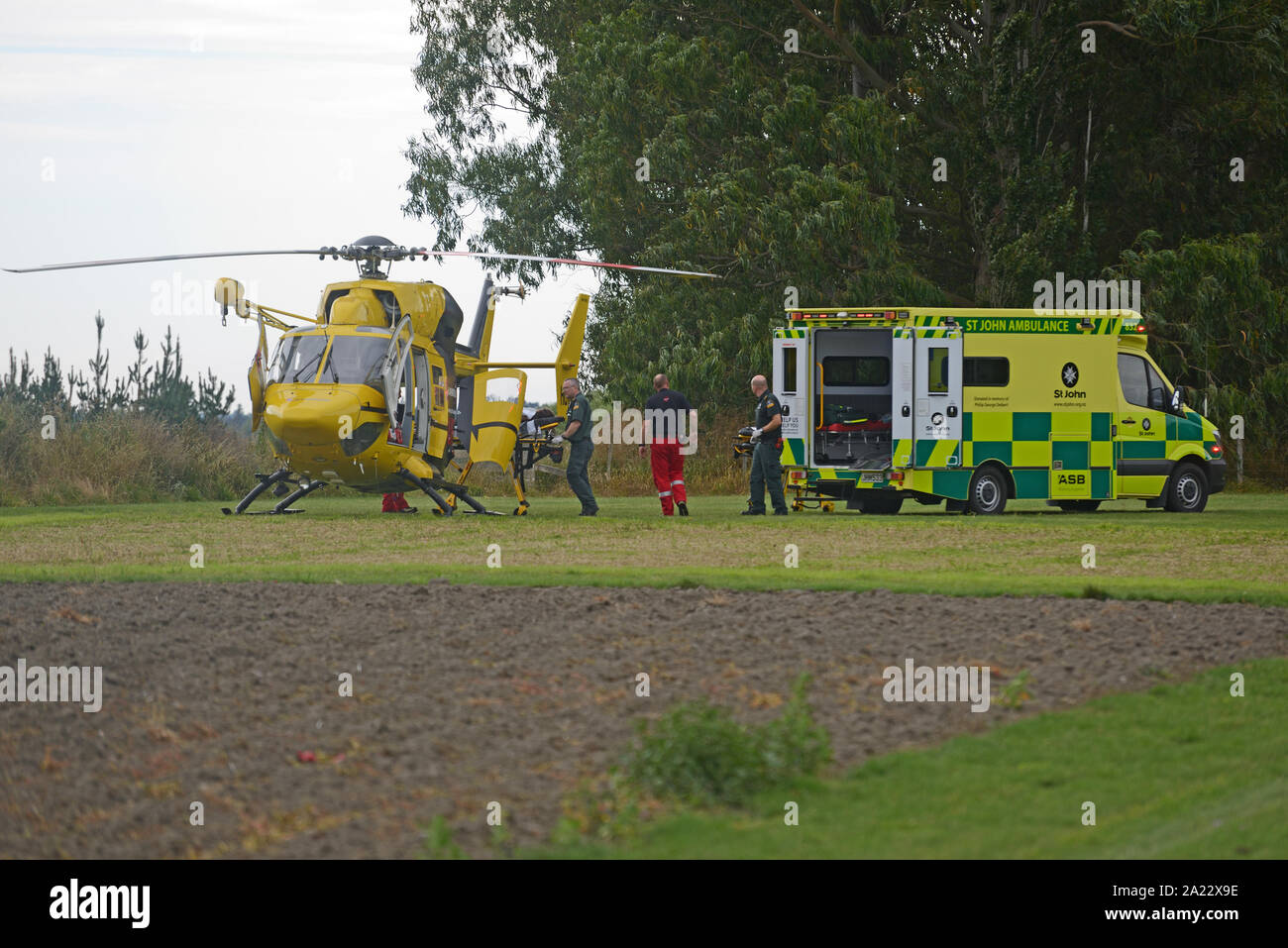 CHRISTCHURCH, Nueva Zelanda, Diciembre 14, 2018: el personal de ambulancias transferir a una persona para que el helicóptero de rescate después de un solo accidente de vehículo Foto de stock