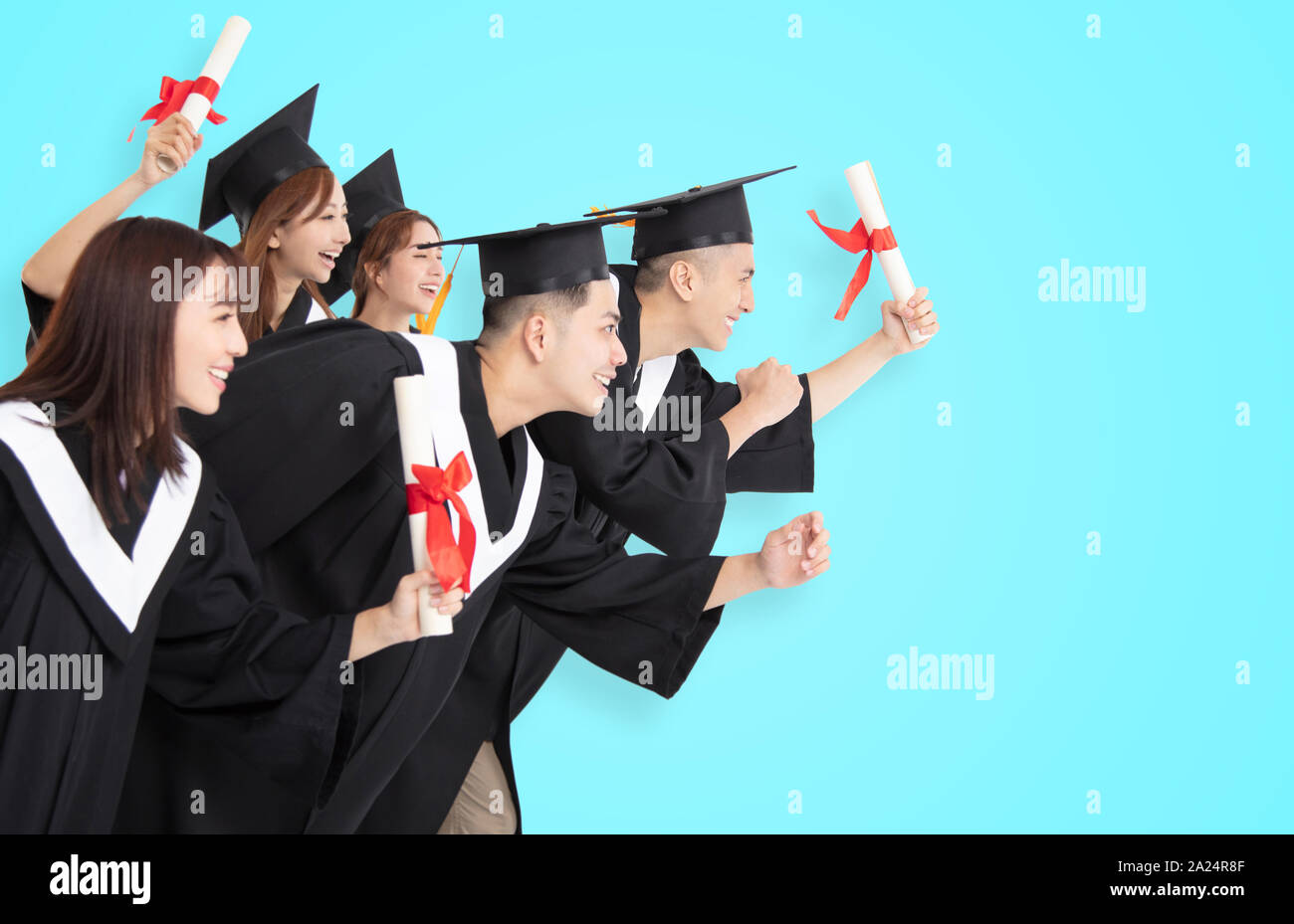 Grupo de Estudiantes en marcha y celebrar la graduación Foto de stock