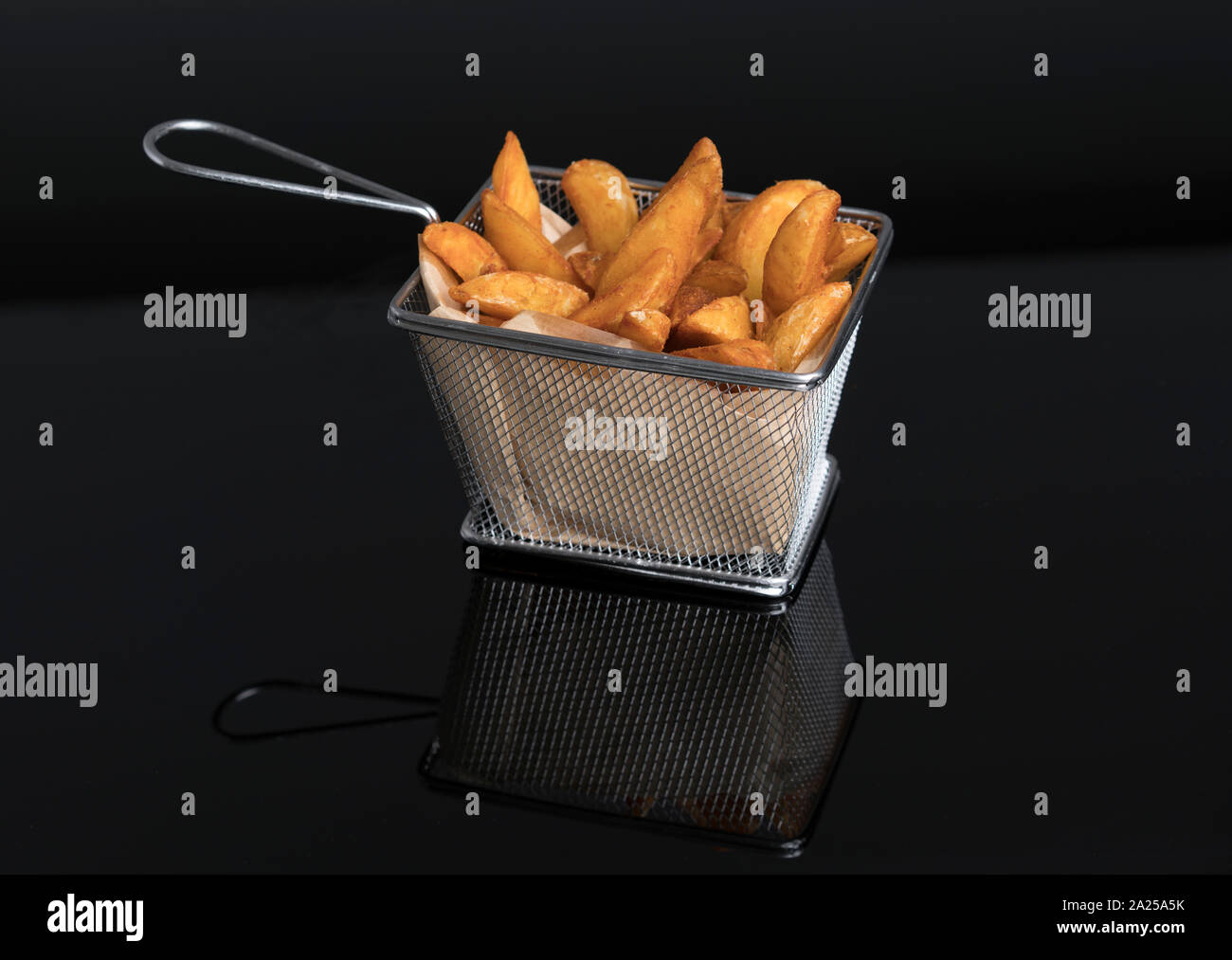Patatas fritas en metacrilato negro en la canasta metálica vista superior Foto de stock