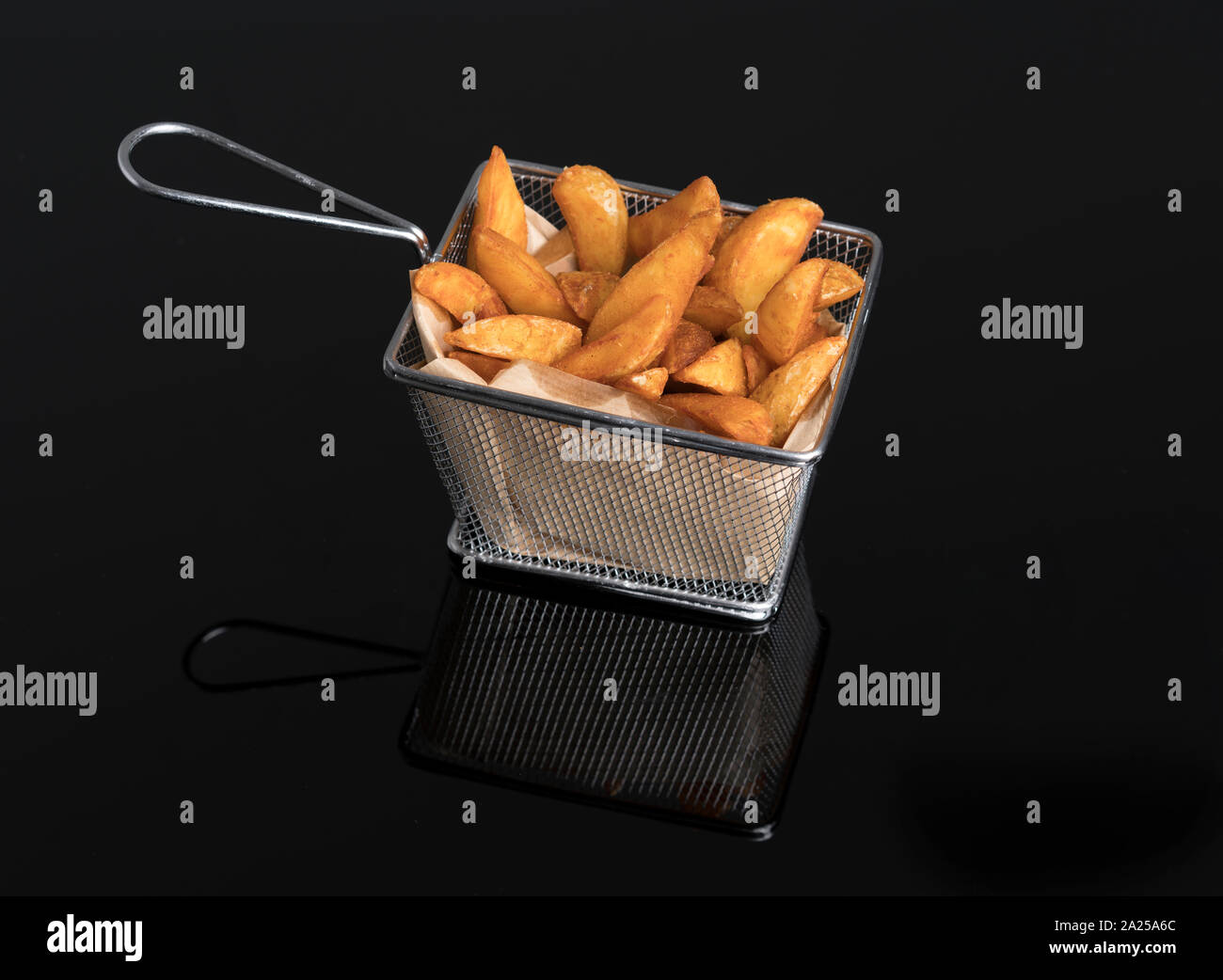 Patatas fritas en metacrilato negro en la canasta metálica Foto de stock