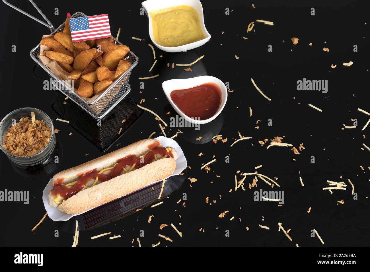 Hot Dog con condimentos, salsas y patatas visto desde arriba con la bandera de EE.UU. Foto de stock