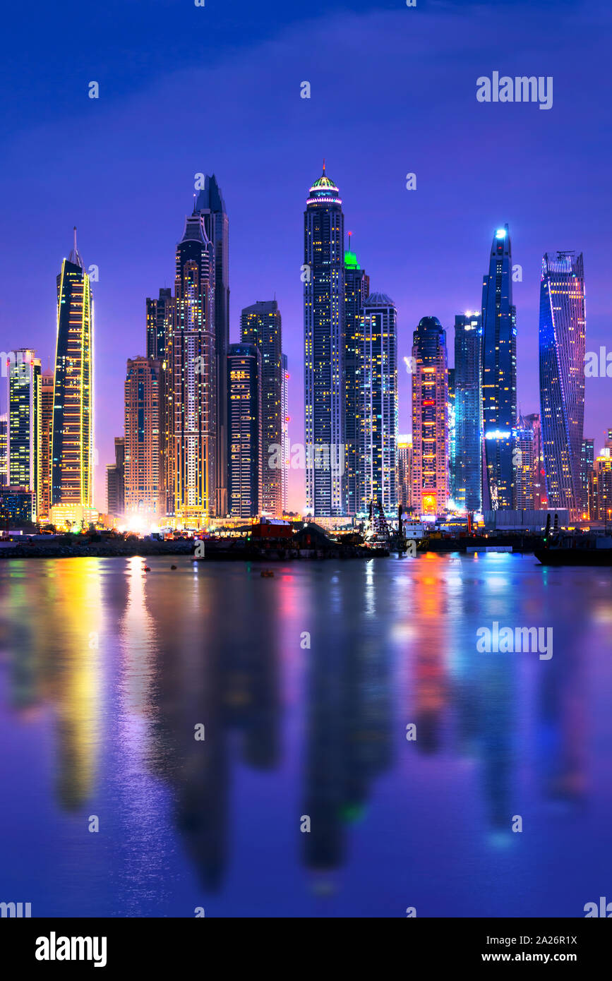 Horizonte de Dubai Marina en la noche con reflejos de agua, Emiratos Arabes Unidos Foto de stock