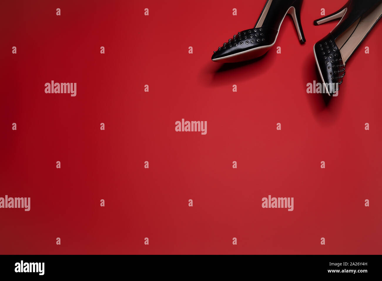 Un par de bombas de cuero negro zapatos con tacones altos picos y sobre  fondo rojo Fotografía de stock - Alamy