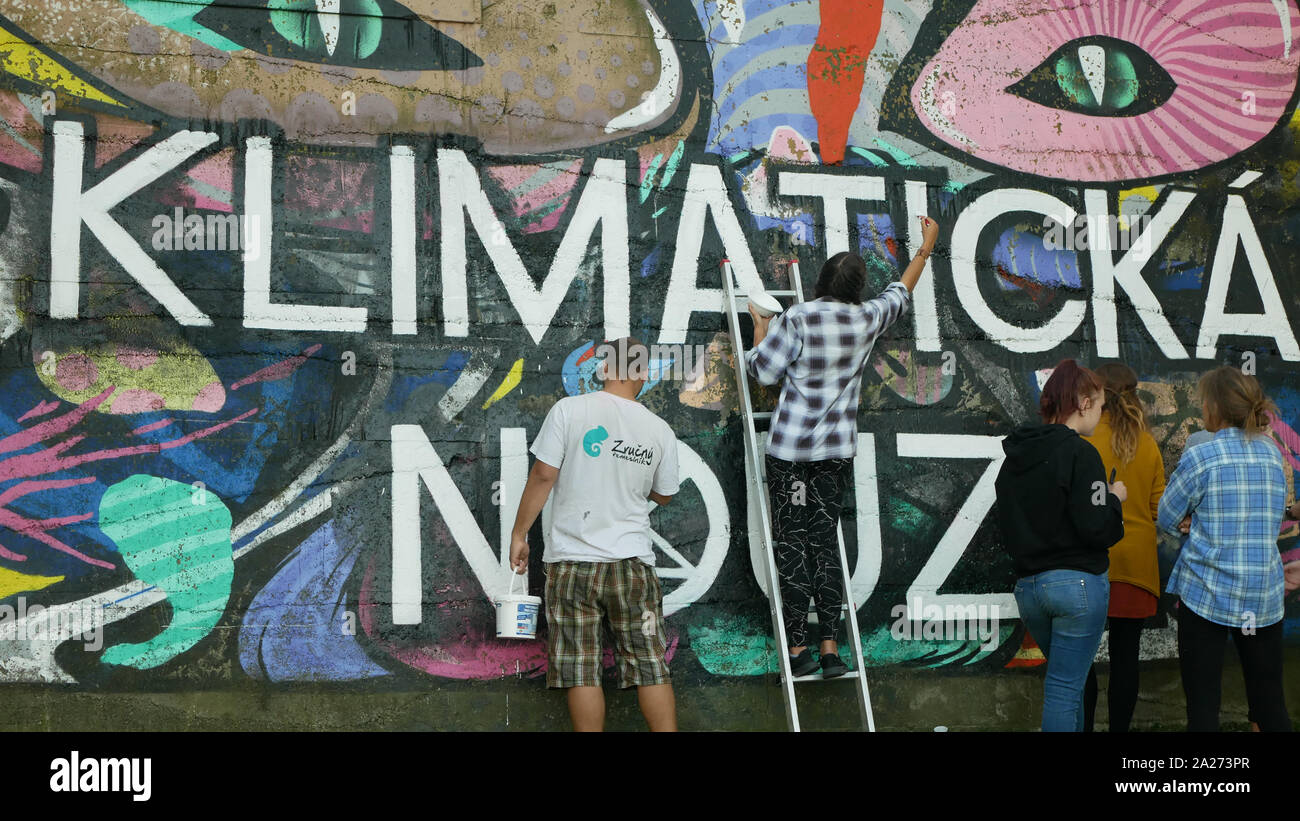 Los activistas personas pinturas y repintado extinción símbolo de rebelión en pared legal para graffiti, demostración de acción contra el cambio climático, la gente Foto de stock