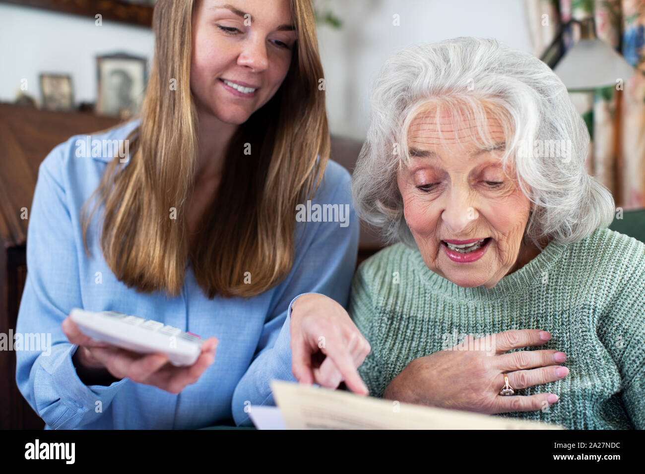 Mujer Senior ayudando al prójimo con facturas y documentación Foto de stock