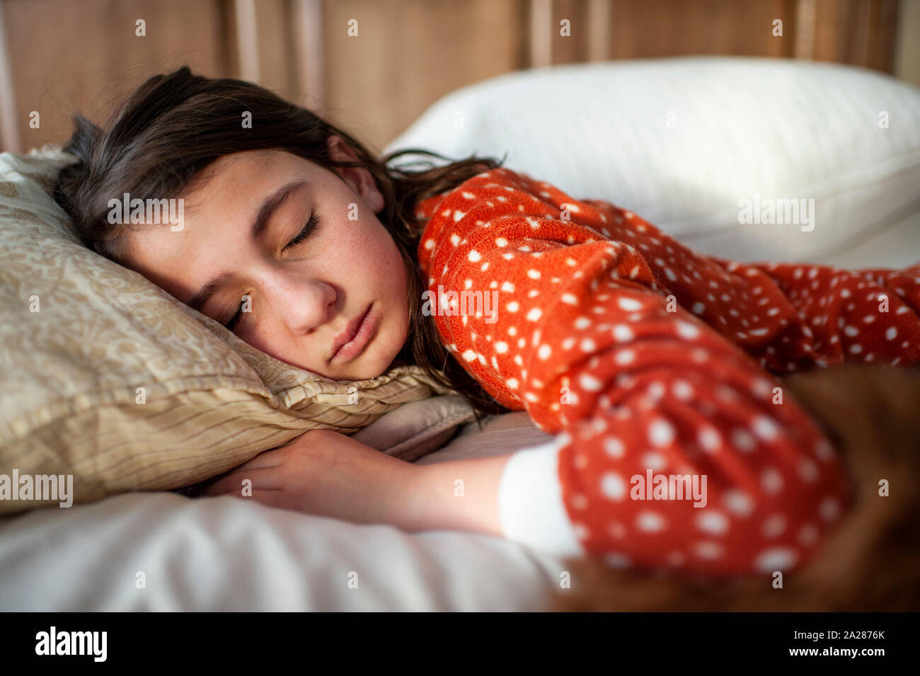 10-12 años de edad chica de interpolación durmiendo en cama en casa Foto de stock