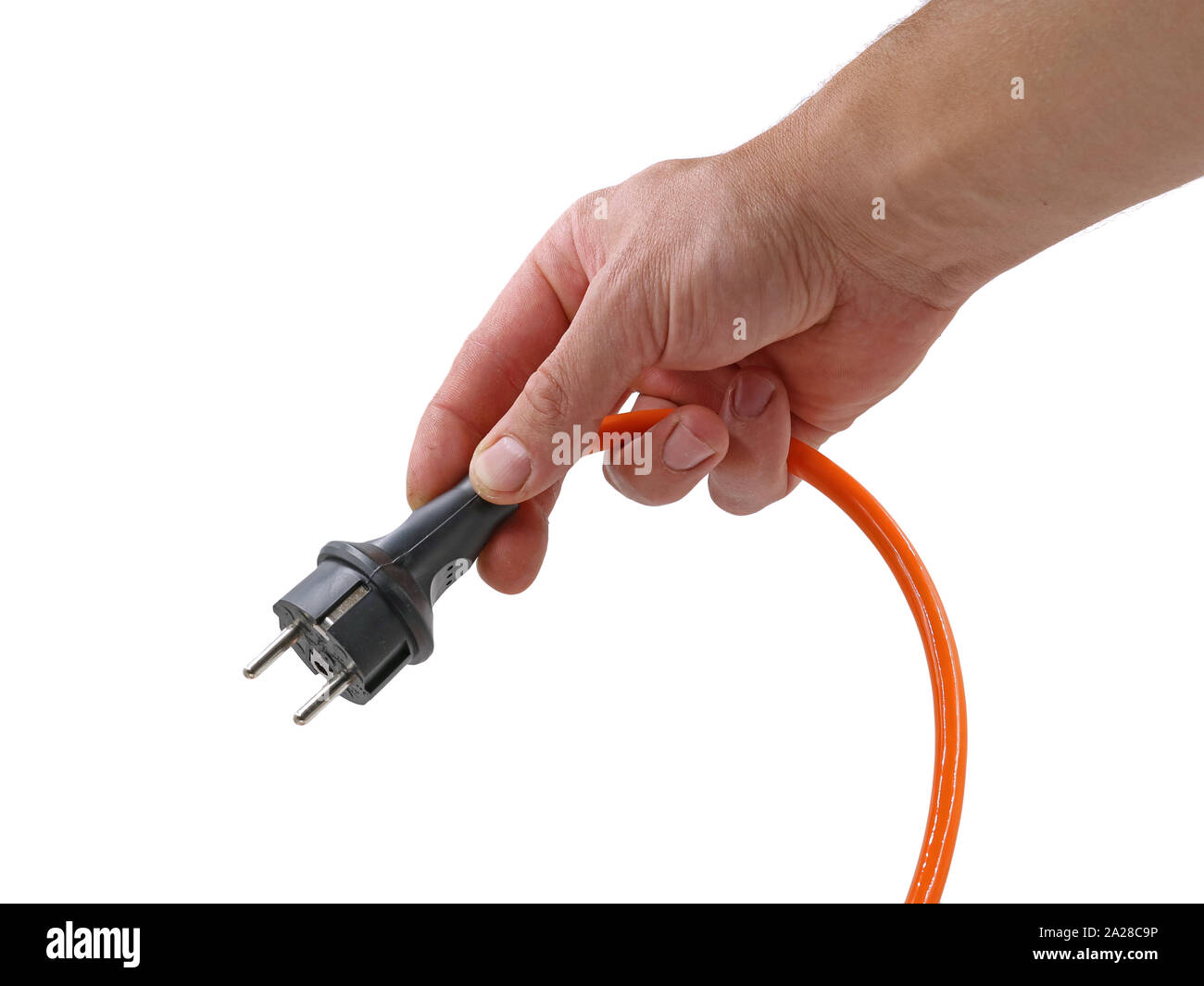 Cerca, macho naranja mano sujetando el cable eléctrico con enchufe aislado sobre fondo blanco. Foto de stock