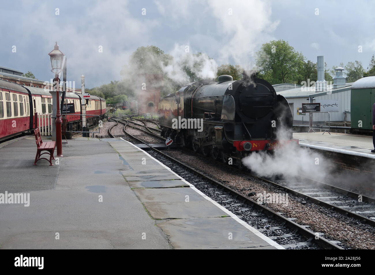 Tren de vapor llegando a una plataforma de la estación. Foto de stock