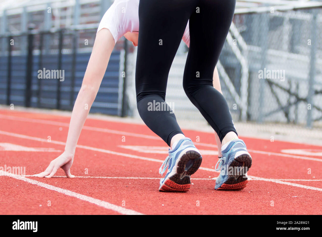 Una escuela secundaria femenina sprinter está en la posición de 'set' en  una pista roja Fotografía de stock - Alamy