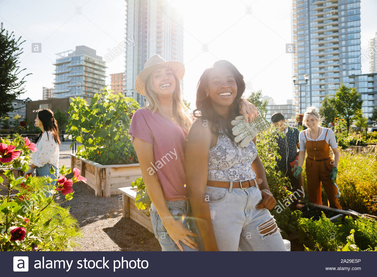 Feliz retrato mujeres jóvenes amigos, comunidad urbana en el soleado jardín Foto de stock