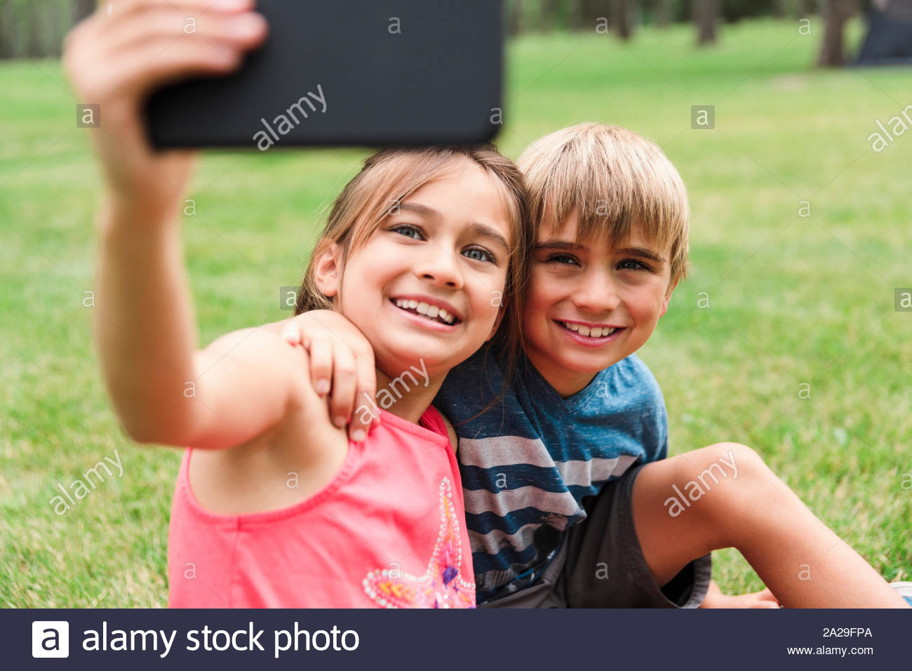 Niña y Niño fotografiando a sí mismos con el smartphone Foto de stock
