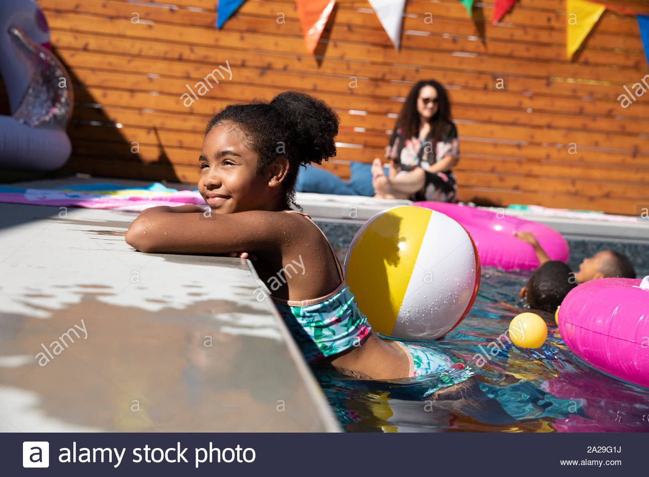 Niña despreocupada, relajarse al borde del soleado, piscina de verano Foto de stock
