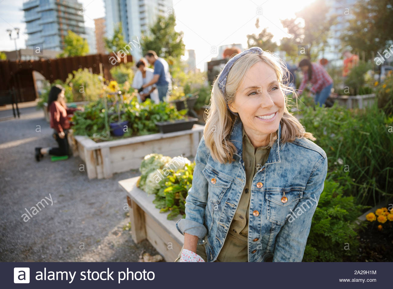 Feliz, despreocupada mujer madura en jardín comunitario urbano Foto de stock