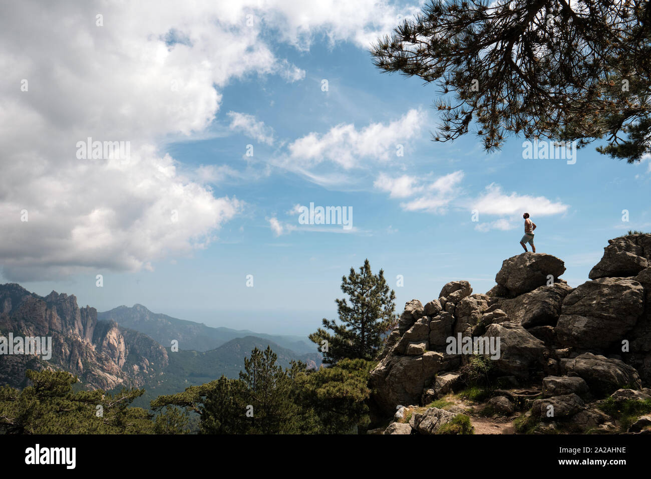 Una solitaria figura disfrutando del paisaje de montaña mirador del Col de Bavella / Aiguilles de Bavella en el Parque Natural Regional de Córcega Foto de stock