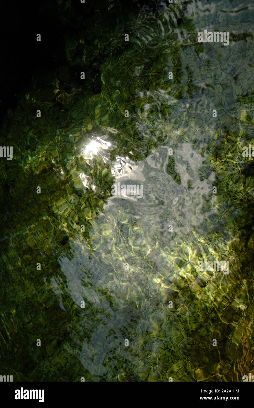 Una piscina natural de agua de arroyos de montaña con sol reflexiones de fondo - naturaleza etérea antecedentes acuosa Foto de stock