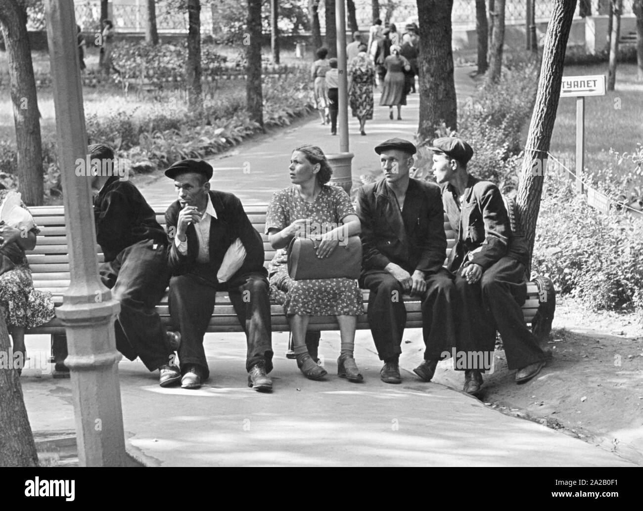 Los visitantes en el Parque Gorky de Moscú, sentarse en un banco del parque en el green. Foto de stock