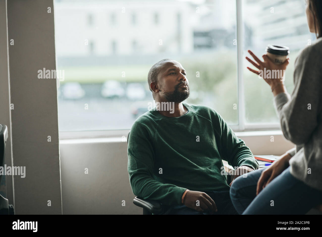 Diseñador americano africano hablando con un colega en el trabajo Foto de stock