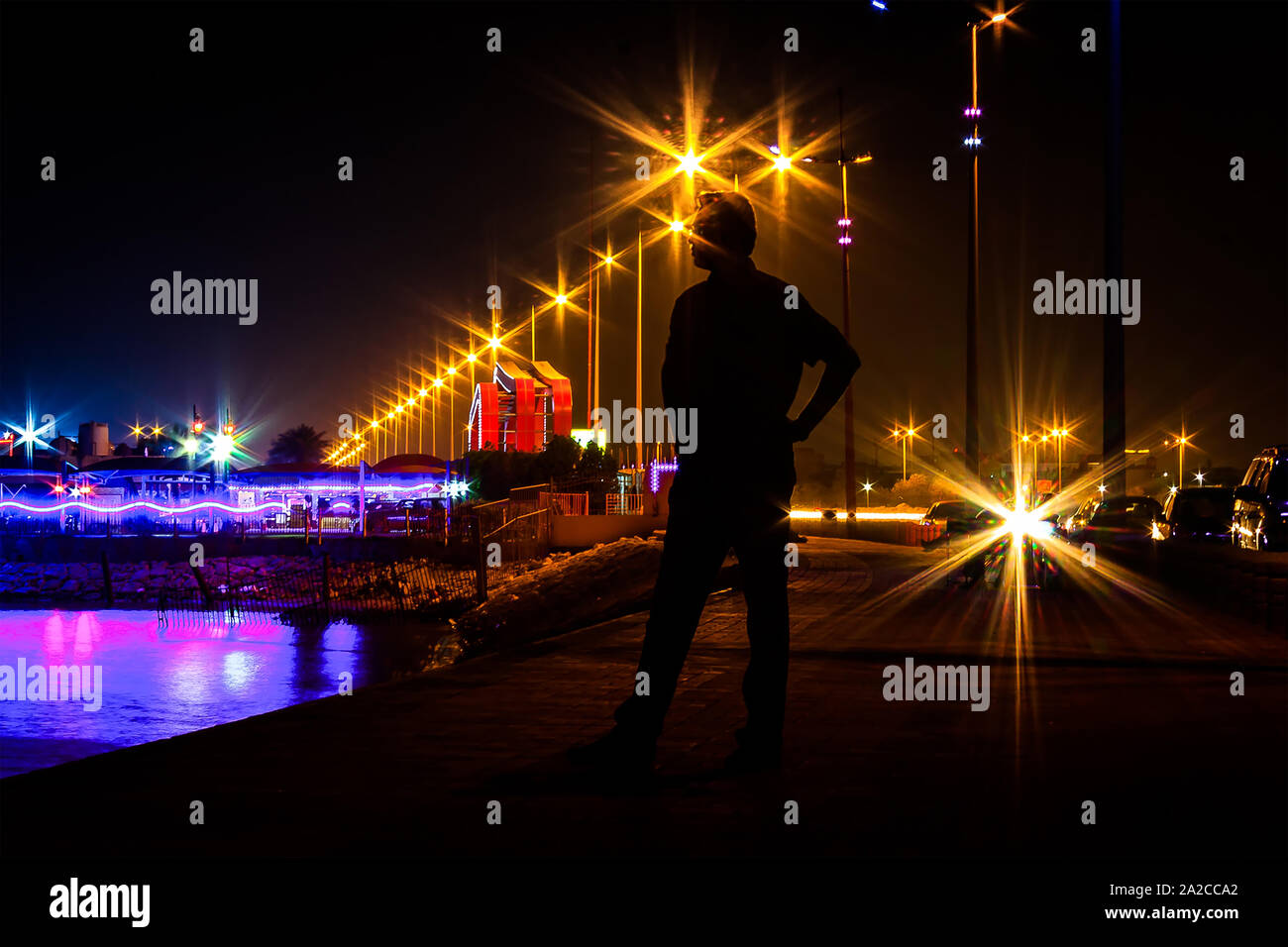 Hombre de pie silueta en la noche estrella burst luz de fondo Foto de stock