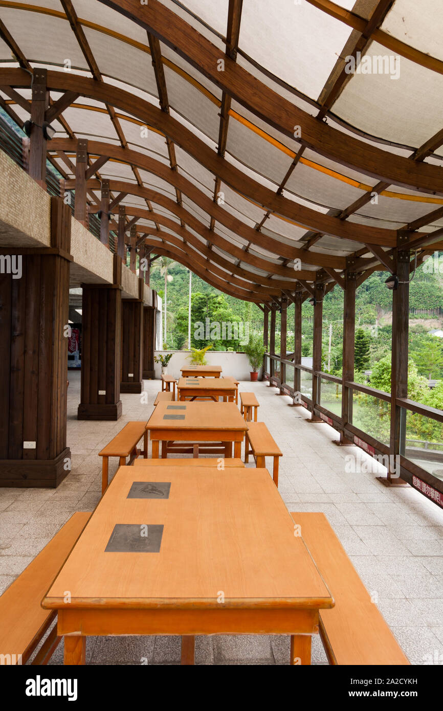 Terraza con mesas y bancos, estructura de techo de vigas de madera con  forma curva en S, cubiertas con láminas de policarbonato, Hualien Taiwán  Fotografía de stock - Alamy