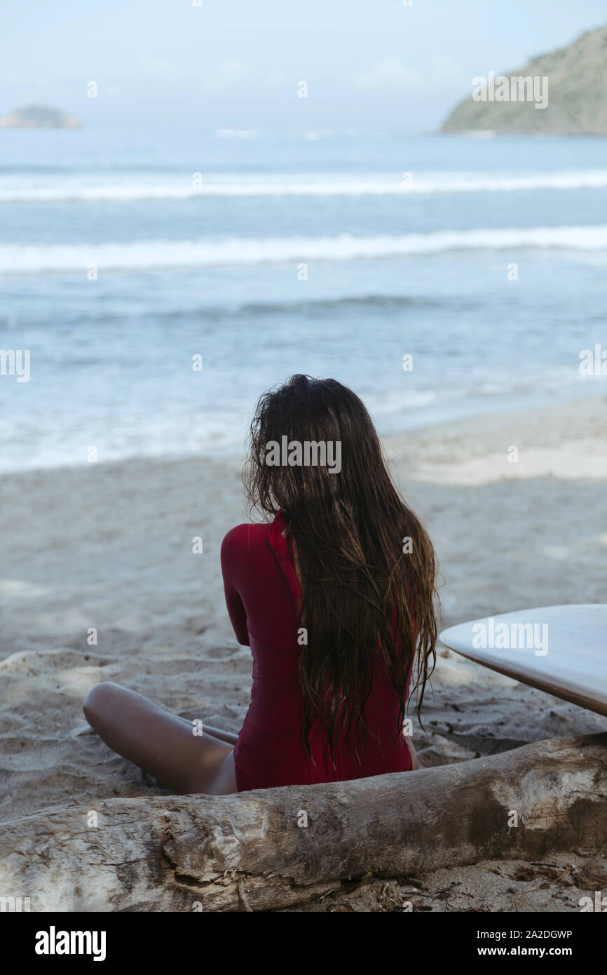 Mujer joven con tablas de surf en la playa. Foto de stock