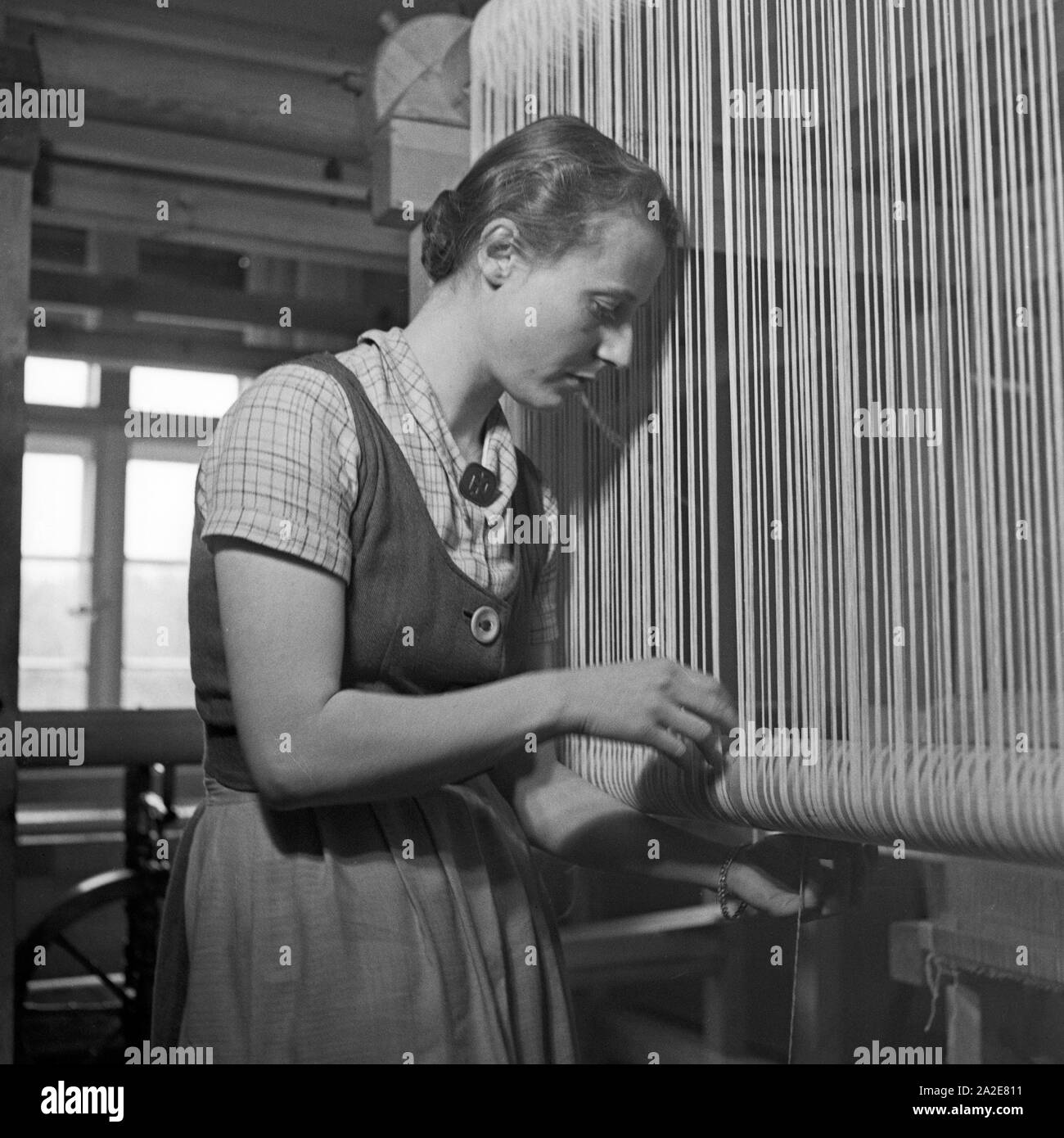 Eine Frau un einem Webstuhl in der in der Kurmark Webschule Sommerfeld, Deutschland 1930er Jahre. Una mujer en un telar en la escuela para tejer en Sommerfeld, Alemania 1930. Foto de stock