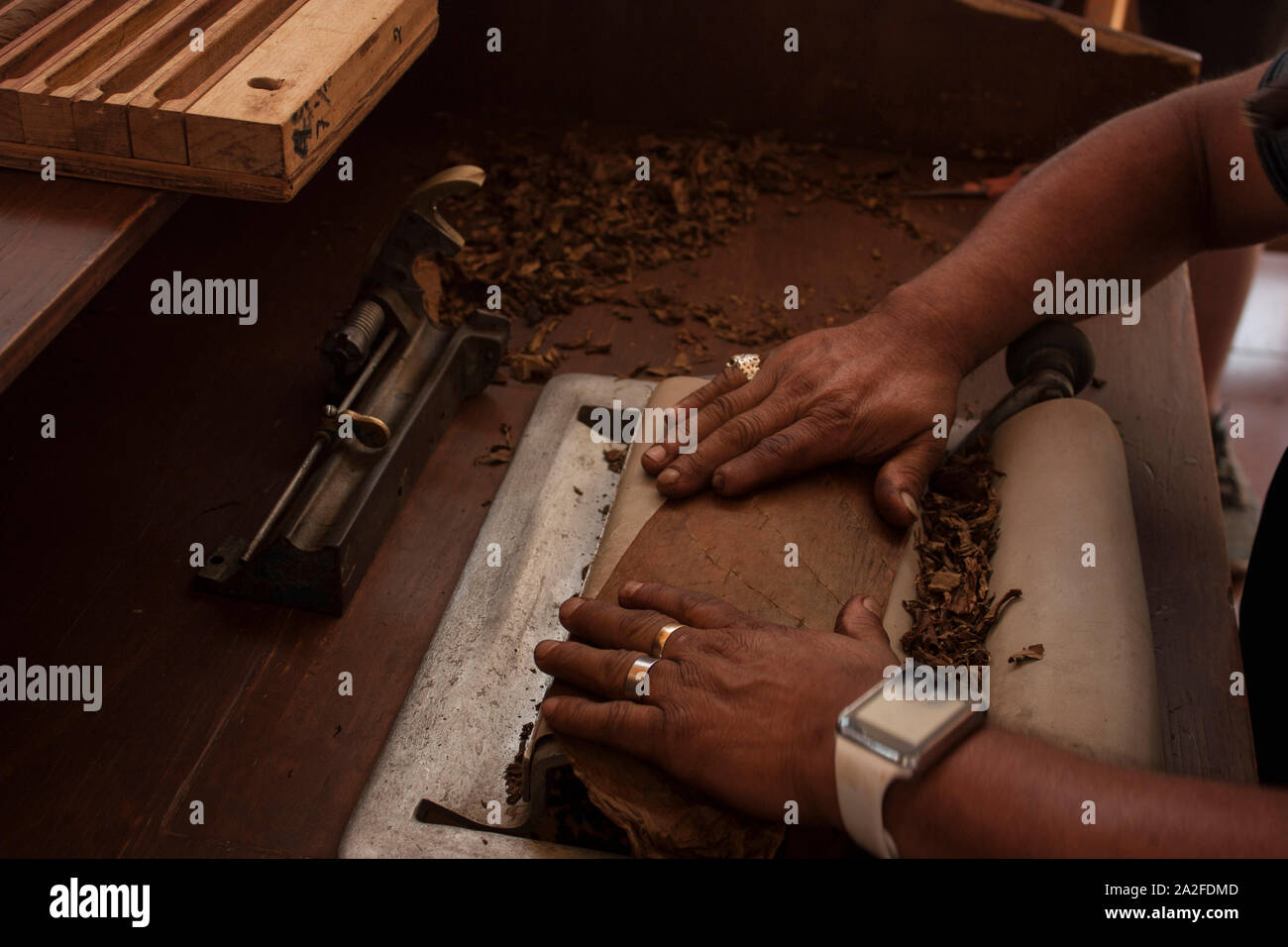 Proceso económico para el tabaco de liar usando una máquina laminadora de mano un trabajador en México Foto de stock
