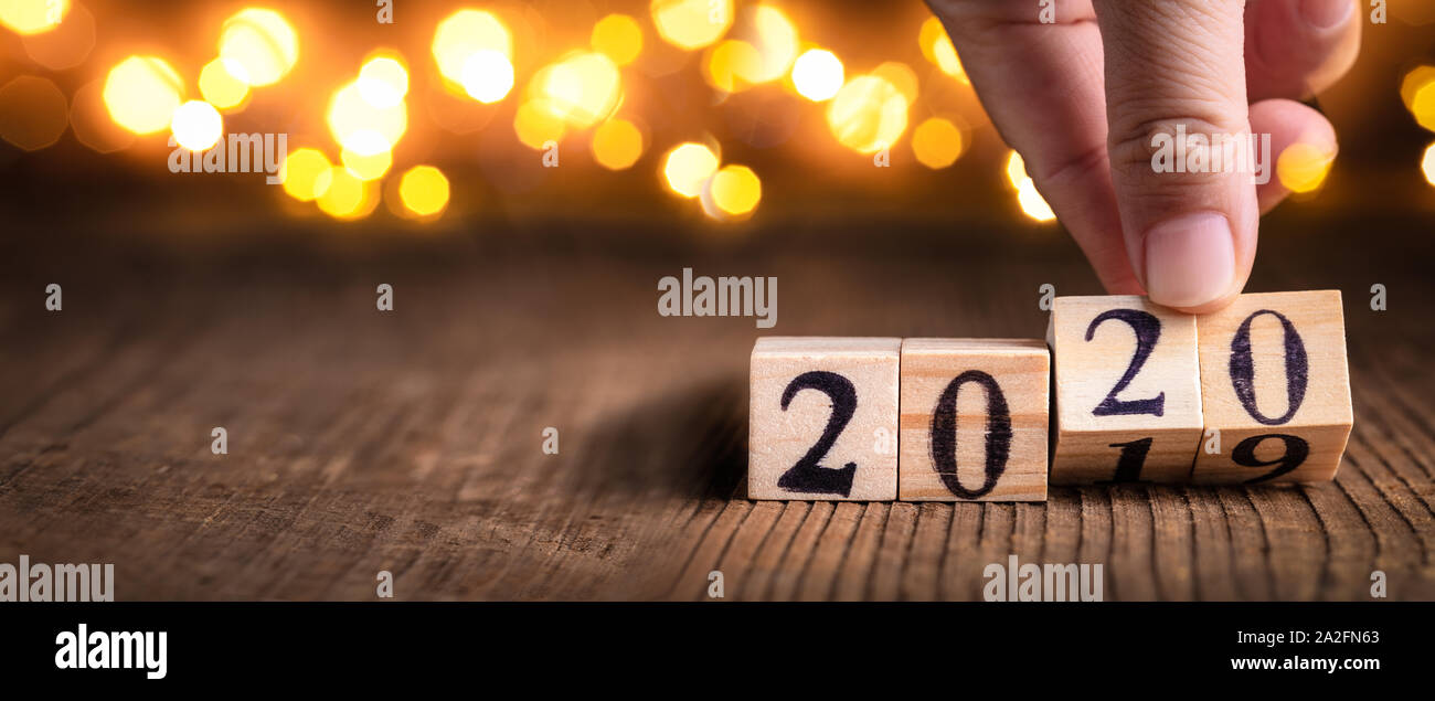 Cubos de madera mano sujetando el calendario con el número 2020, feliz año nuevo 2020 concepto. Foto de stock