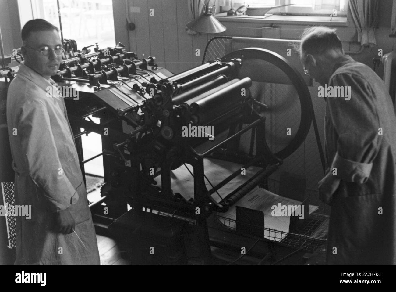 Un einer Druckerpresse Arbeiter, Deutschland 1930er Jahre. Trabajador en una imprenta, Alemania 1930. Foto de stock