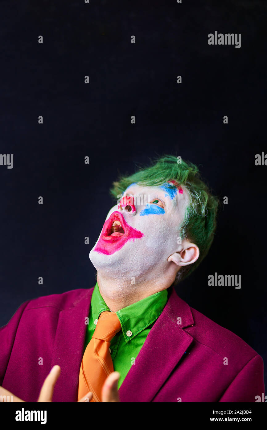 Hombre en mime cosplay maquillaje con cabello verde y un traje rojo una  corbata naranja y una camiseta verde Fotografía de stock - Alamy