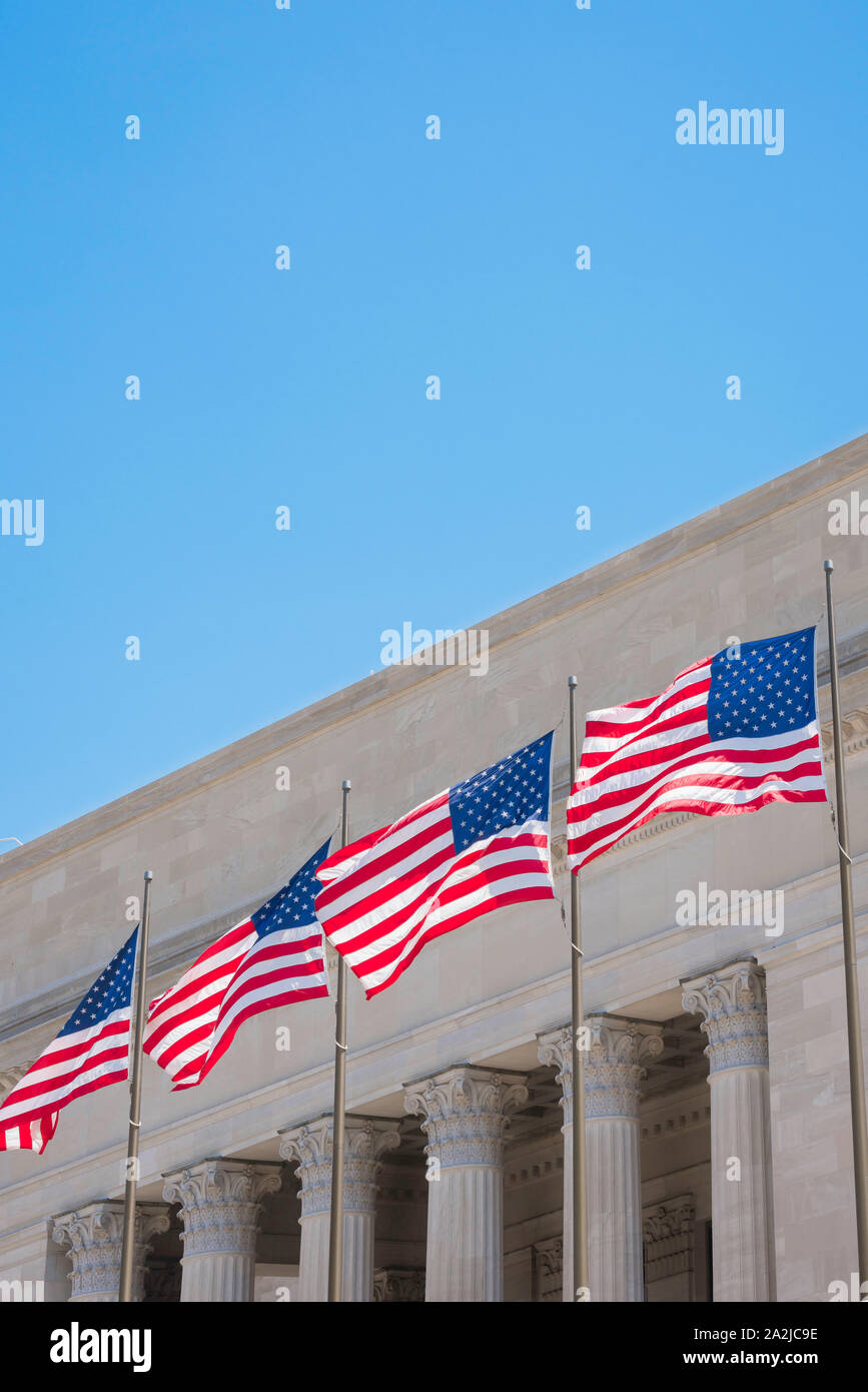 Poder americano, vista de cuatro banderas nacionales de EE.UU. Situadas fuera de un edificio de corte de estilo neoclásico americano. Foto de stock