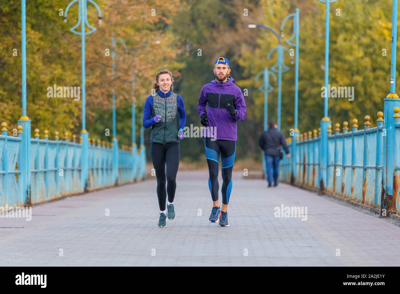 Los corredores fitness par corriendo en el parque de la ciudad. Pareja activa outdor para correr por la mañana Foto de stock