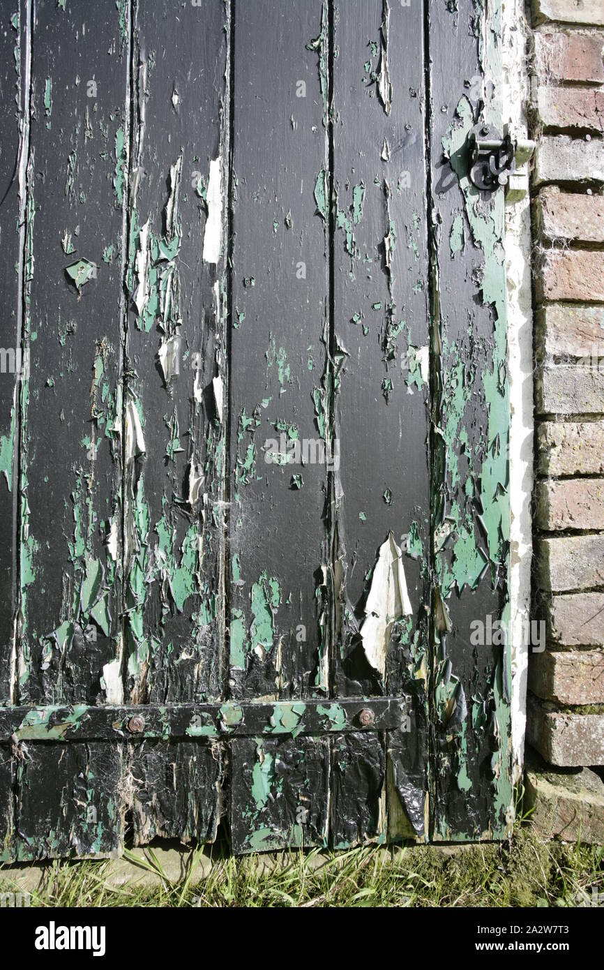 Viejo tiempo gastado exterior puerta de madera con la pintura descarapelada Foto de stock