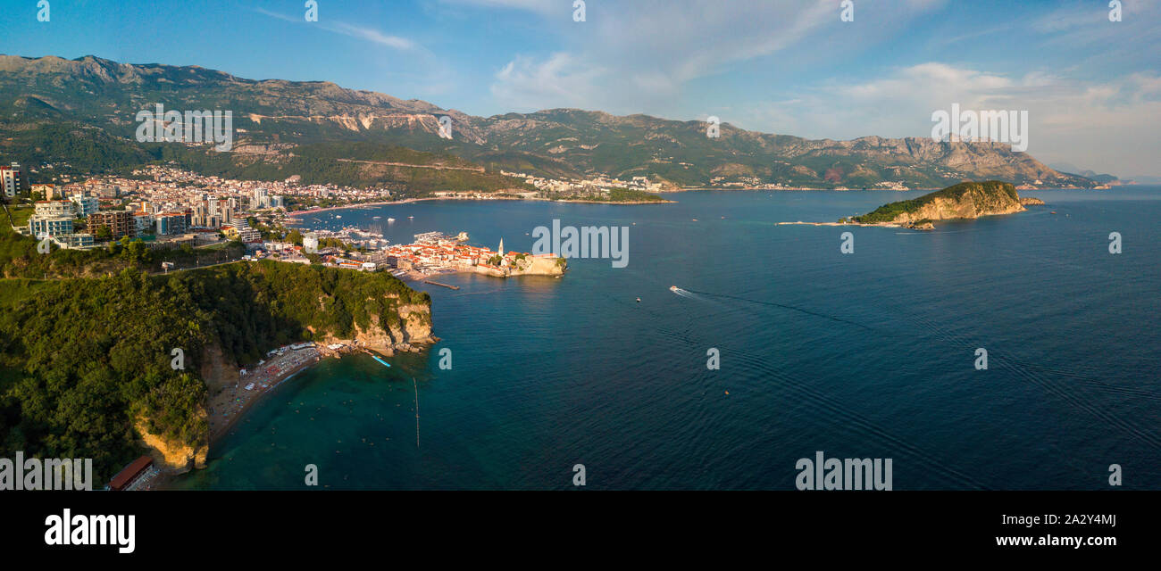 Vista aérea de la playa Mogren (dos playas de arena) y la ciudad vieja (Stari Grad) de Budva, y la isla de Sveti Nikola. Montenegro. Dentado costa Foto de stock
