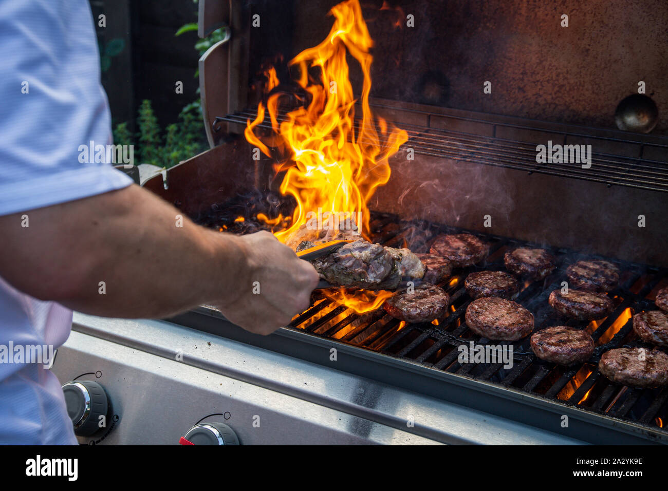 Hamburguesas de carne y corderos marinados cocinando en una barbacoa de jardín Foto de stock
