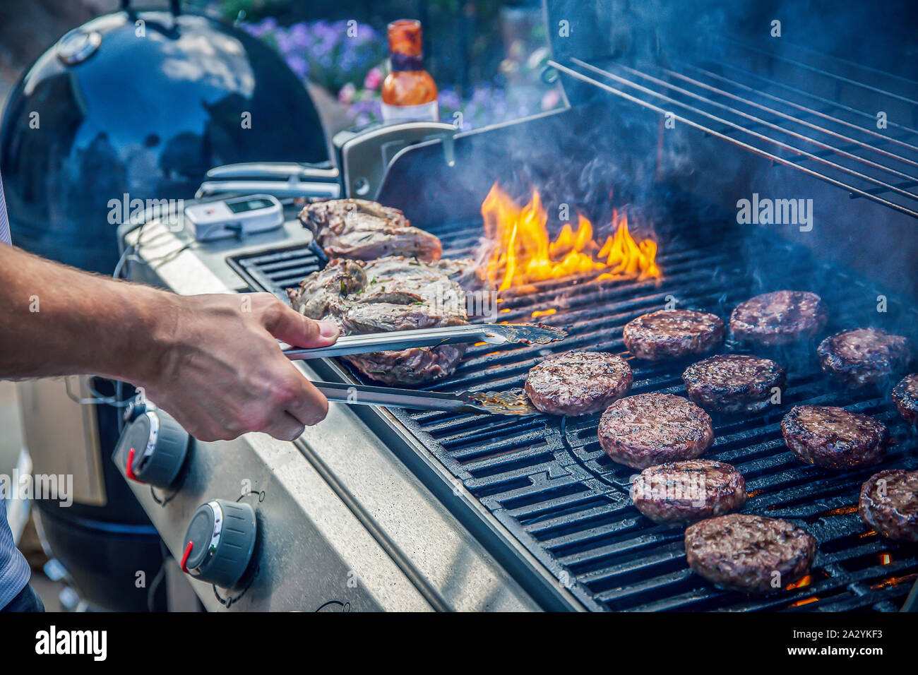 Hamburguesas de carne y corderos marinados cocinando en una barbacoa al aire libre Foto de stock