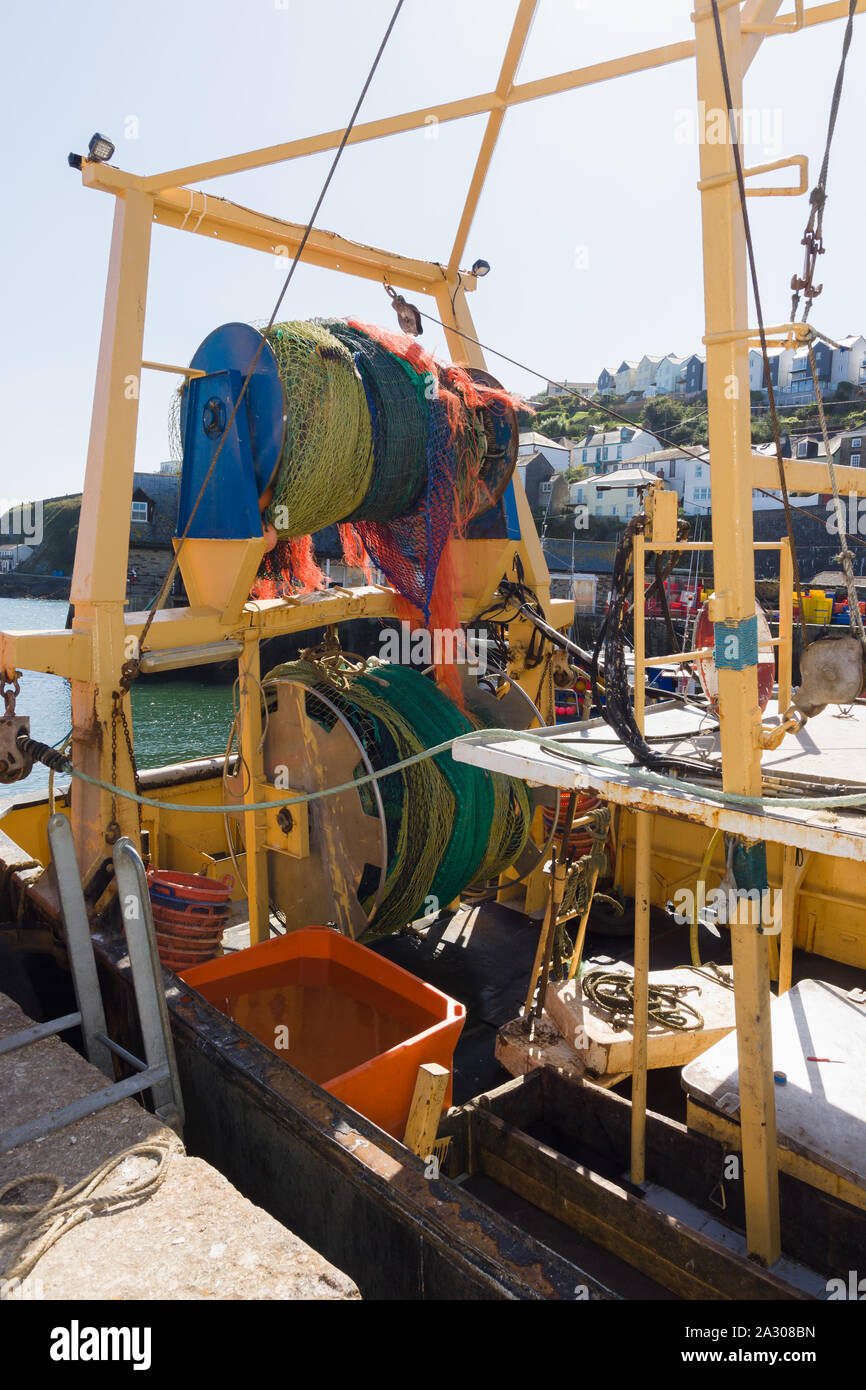 Las redes de arrastre enrollado en net tambores una amplia powered carrete en la popa de un buque de pesca comercial en Mevagissey Harbour en Cornualles, Inglaterra Foto de stock
