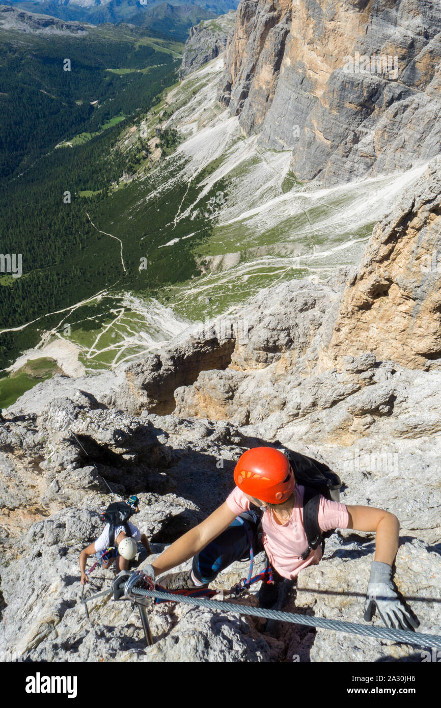 Varios jóvenes alpinistas en muy expuesta Vía Ferrata en Alta Badia en las dolomitas italianas Foto de stock