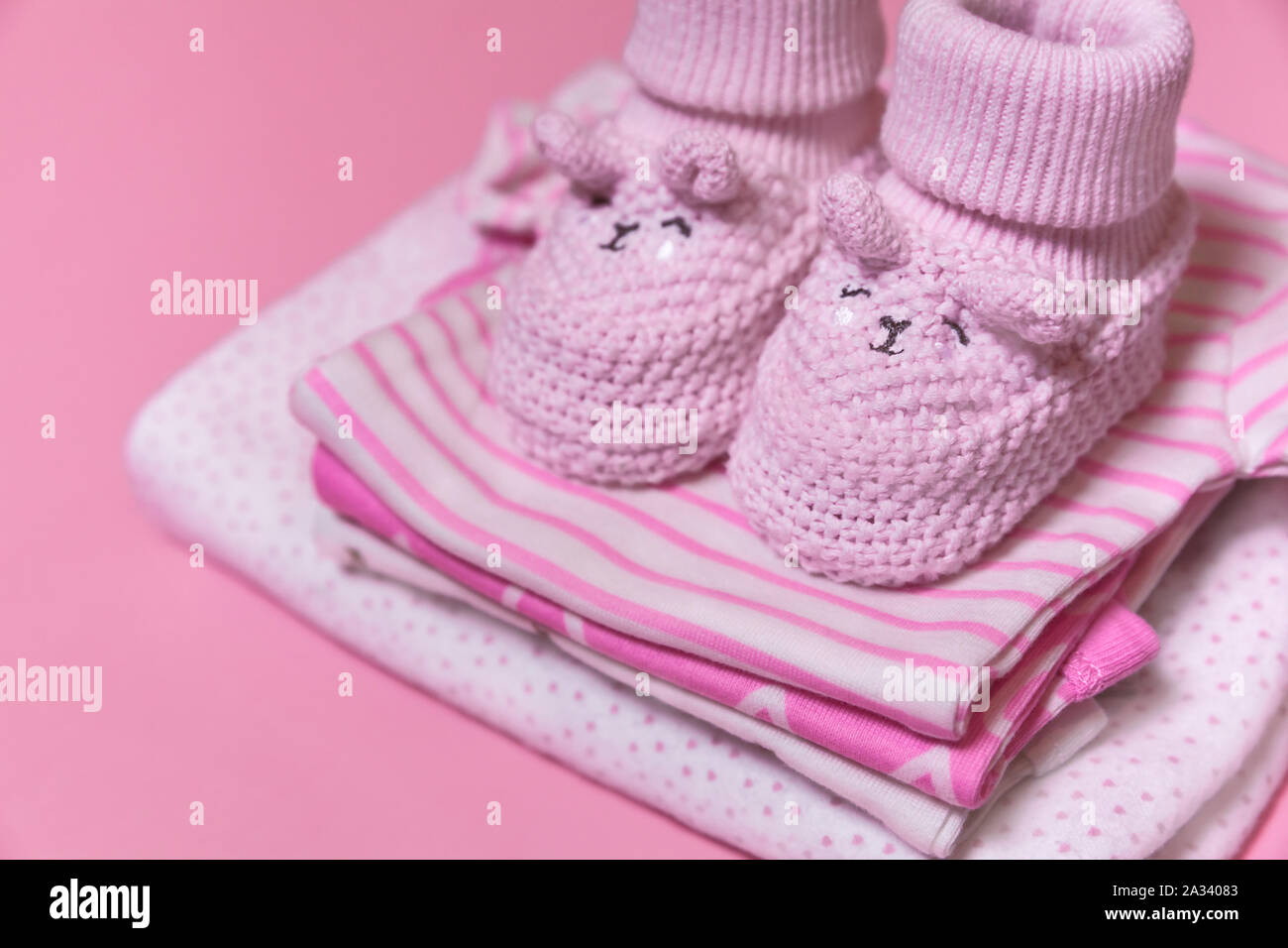 Montaña Comorama Delegar Ropa de bebé y ganchillo zapatos para una niña recién nacida sobre un fondo  de color rosa, el embarazo concepto - Imagen Fotografía de stock - Alamy