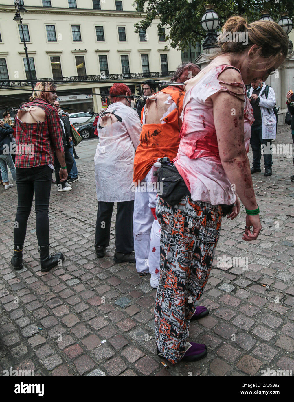 Londres, Reino Unido. El 05 de octubre de 2019. Mientras que la mayoría de los participantes de este año para el día Zombie en Londres ,elegir para vestir y utilizar maquillaje para lucir como scary posible ,este grupo decide ir por el impacto permitiéndose ser tirado por ganchos fijados a sus espaldas por las calles de Londres . Pablo Quezada-Neiman/Alamy Live News Foto de stock