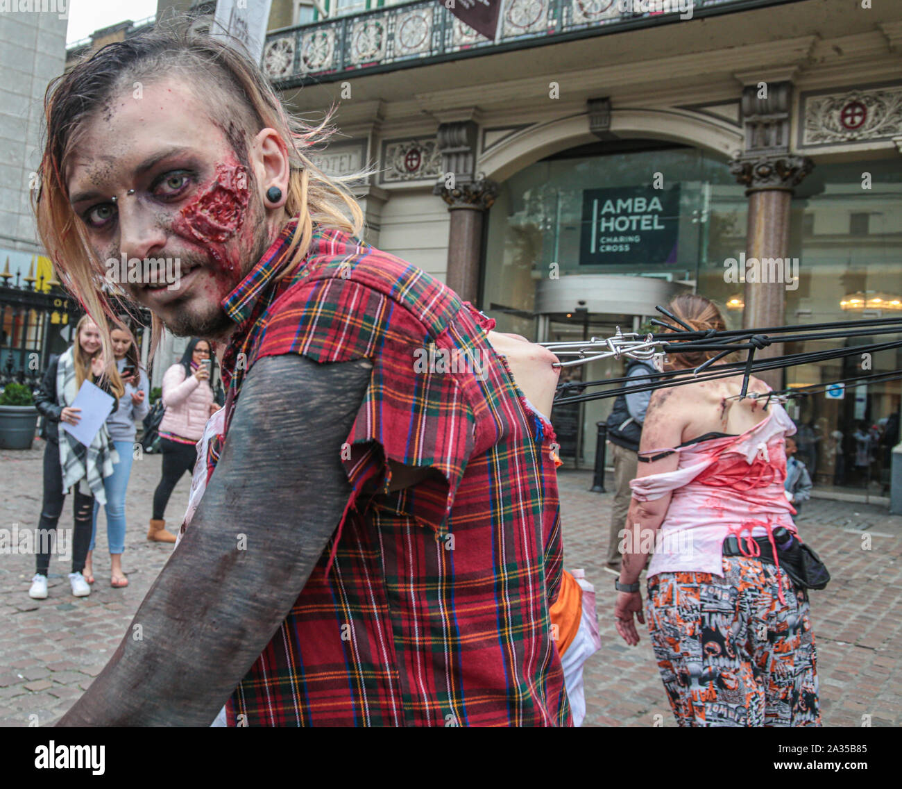 Londres, Reino Unido. El 05 de octubre de 2019. Mientras que la mayoría de los participantes de este año para el día Zombie en Londres ,elegir para vestir y utilizar maquillaje para lucir como scary posible ,este grupo decide ir por el impacto permitiéndose ser tirado por ganchos fijados a sus espaldas por las calles de Londres . Pablo Quezada-Neiman/Alamy Live News Foto de stock